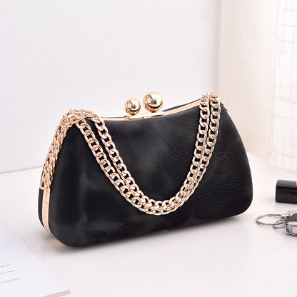 Black textured clutch bag with gold-tone chain shoulder strap and kiss-lock clasp