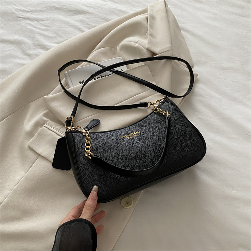Black pebbled shoulder crossbody bag with gold chain strap and long adjustable shoulder strap