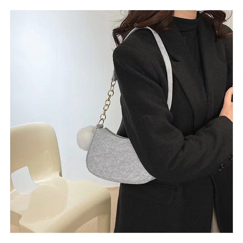 Felt crossbody bag in gray with gold chain strap and curved side flap