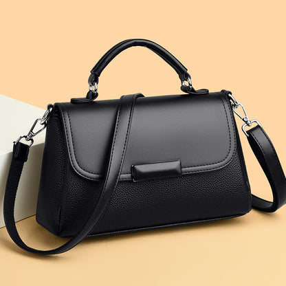 Black women’s top-handle handbag with textured finish, front flap, and crossbody strap