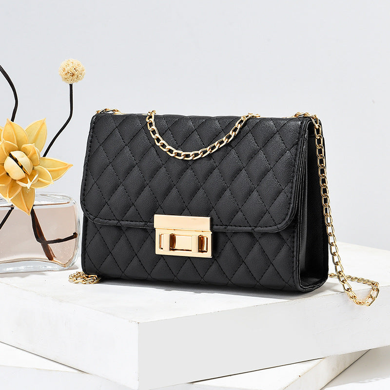 Black quilted mini square crossbody bag with gold chain and front turn-lock clasp
