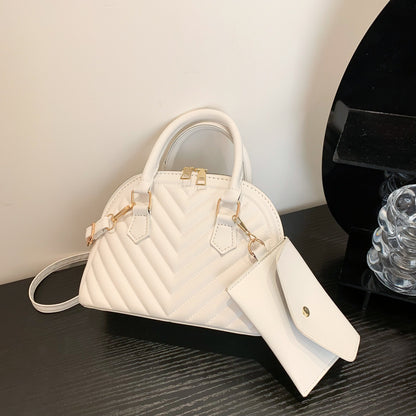 White quilted women's shoulder messenger bag with gold hardware and dangling strap tag