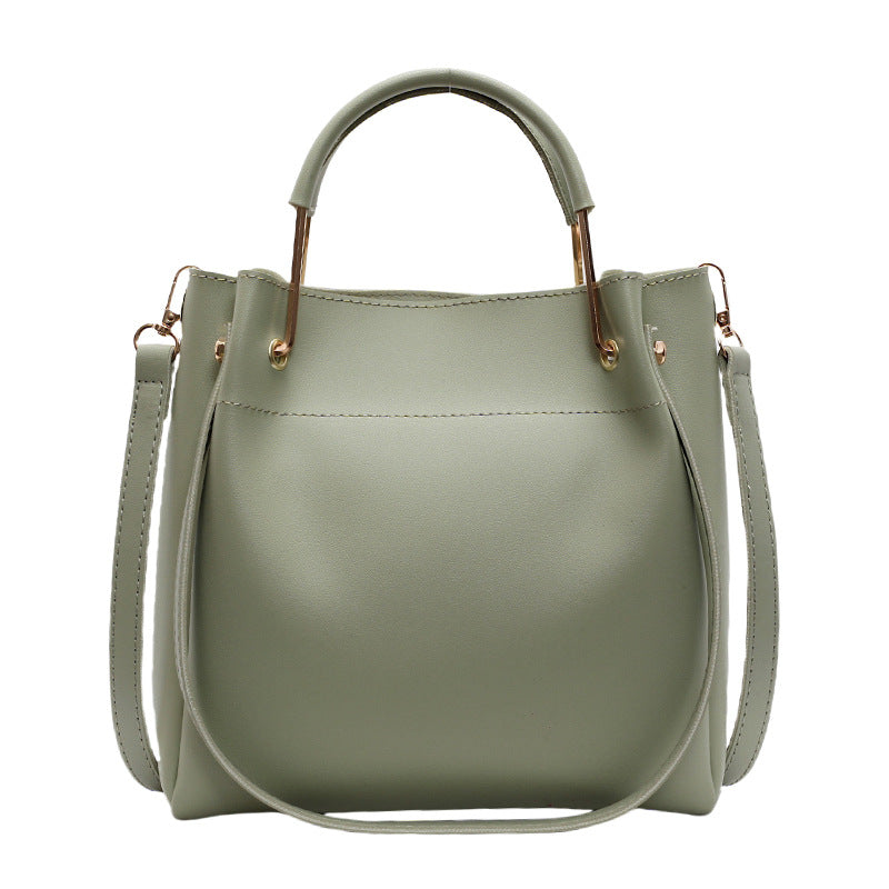 Sage green bucket bag with structured shape, top handle, and side strap