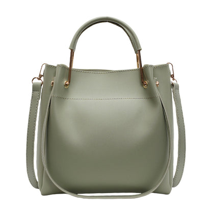 Sage green bucket bag with structured shape, top handle, and side strap