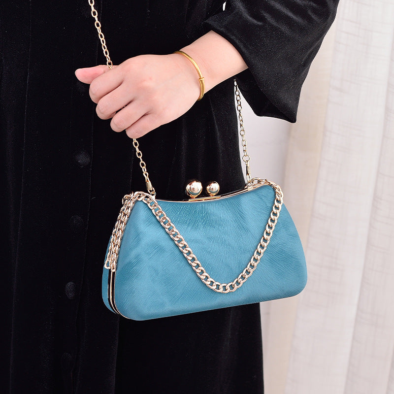 Blue clutch bag with gold-tone chain crossbody strap and kiss-lock clasp frame